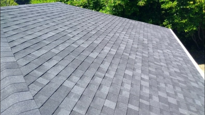 Close angle of a finished asphalt shingle roof against clear sky