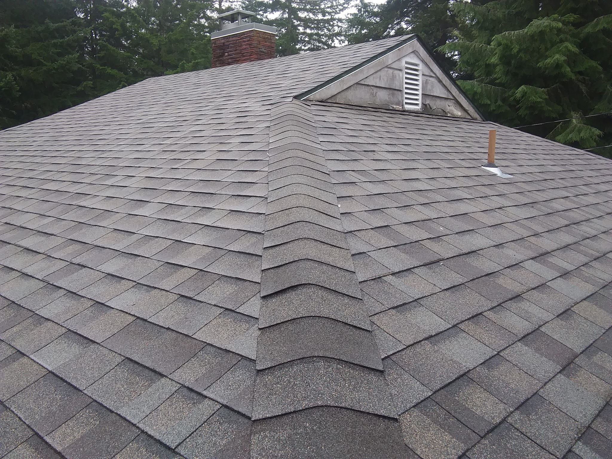 Finished asphalt shingle roof with chimney and dormer flashing detail
